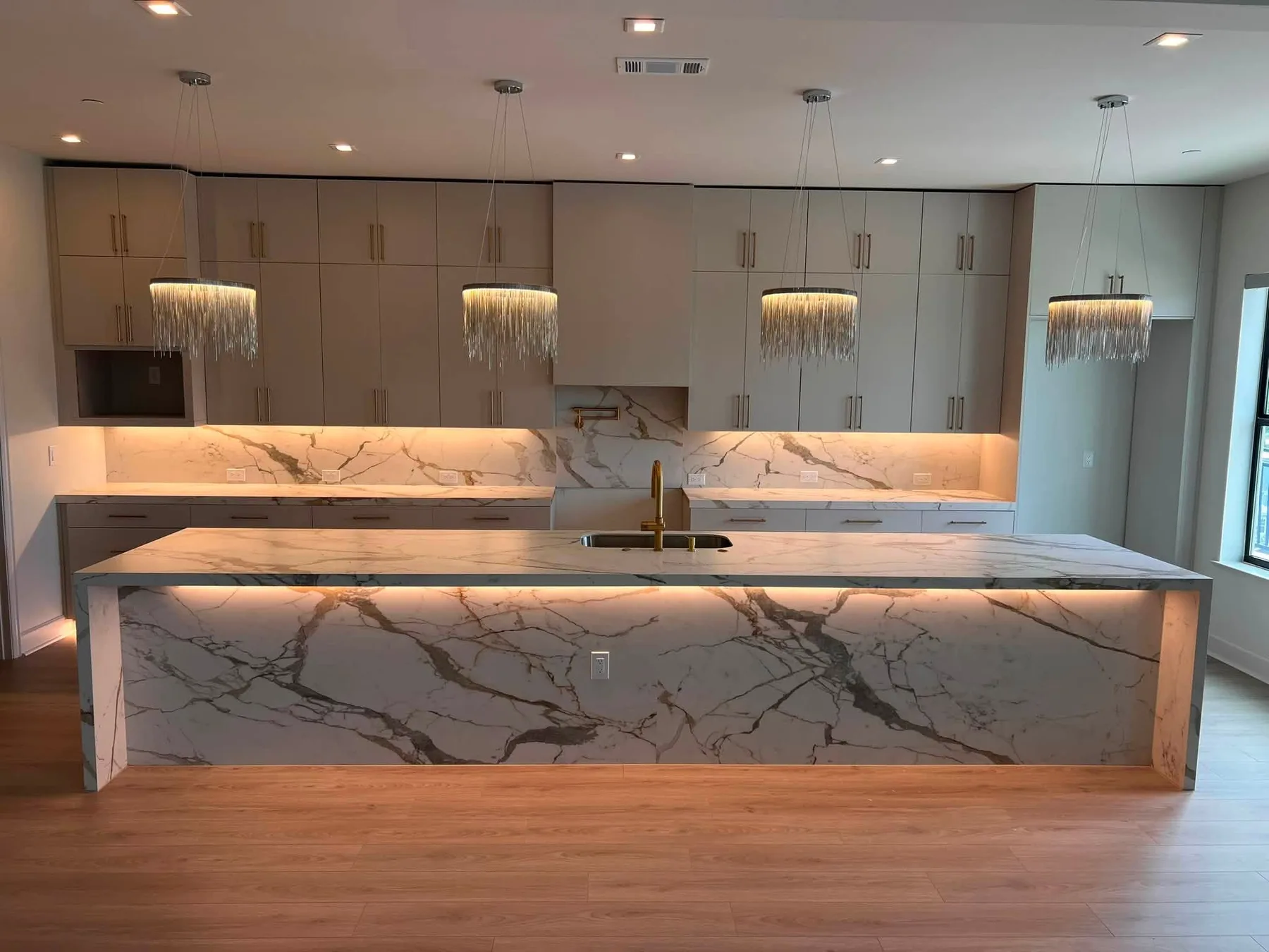 Porcelain waterfall island with a full-height slab backsplash
